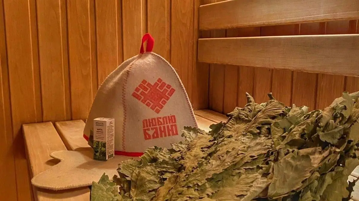 Банная шапка и веник в русской парной